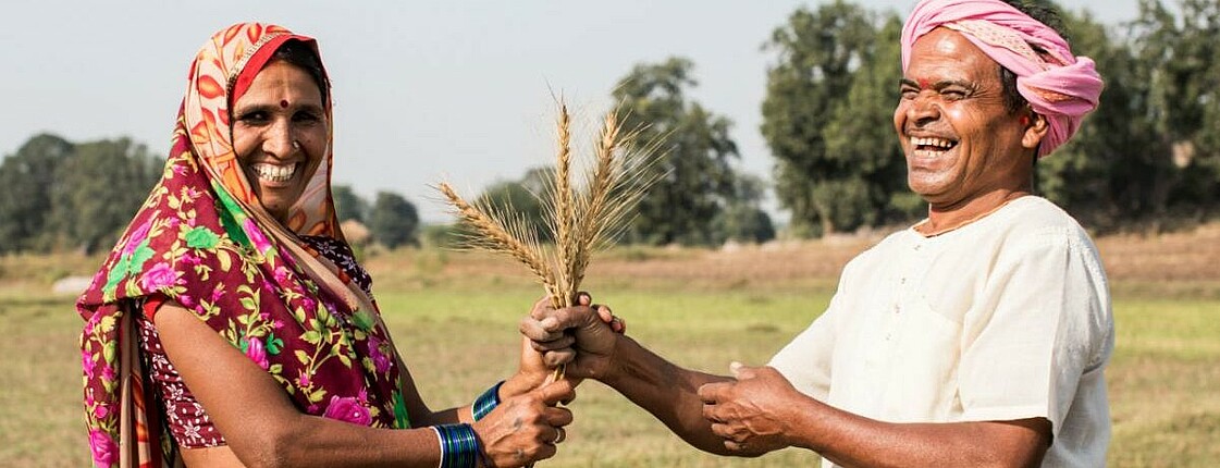 Das Bild zeigt einen lachenden Mann und eine lachende Frau welche ihr Saatgut zeigen