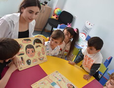 Eine Pädagogin betreut Kinder in der Caritas-Kinderbetreuung, während ihre Mütter an Weiterbildungen teilnehmen.