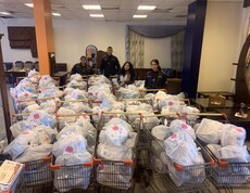 Mitarbeiter*innen der Caritas Libanon stehen vor vielen Einkaufswagen, welche sie mit, in Plastik verpackte Hilfsgüter gefüllt haben