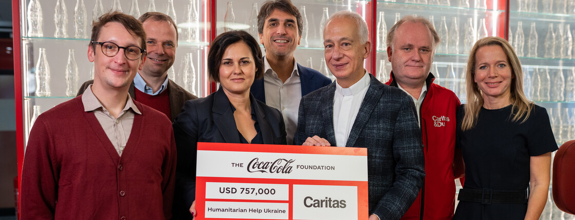 Vertreter*innen von Coca-Cola und Caritas Österreich bei der Scheckübergabe