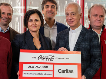 Vertreter*innen von Coca-Cola und Caritas Österreich bei der Scheckübergabe