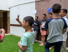 Im Straßenkinderzentrum wird durch gemeinsames Spielen die Entwicklung der Kinder gefördert.  Eine Gruppe Kinder spielt auf einem Fußballrasen