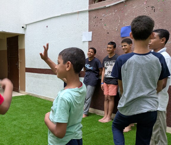 Im Straßenkinderzentrum wird durch gemeinsames Spielen die Entwicklung der Kinder gefördert.  Eine Gruppe Kinder spielt auf einem Fußballrasen