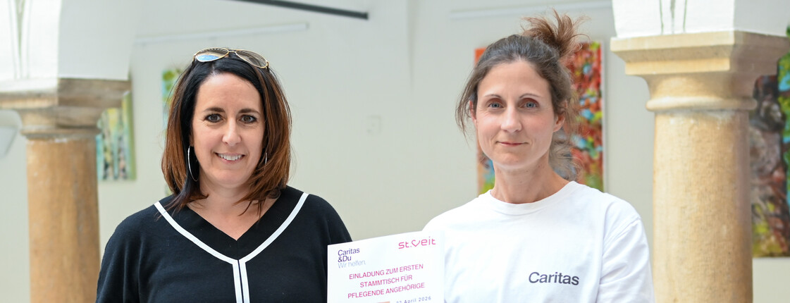 Ein Portrait von Verena Wernbacher (RegionalCaritas) und Stadträtin Sylvia Greiler mit dem Plakat zum Pflegestammtisch (v.r.n.l.)