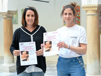 Ein Portrait von Verena Wernbacher (RegionalCaritas) und Stadträtin Sylvia Greiler mit dem Plakat zum Pflegestammtisch (v.r.n.l.)