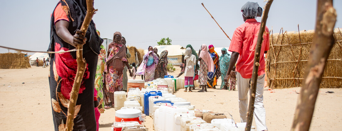 Menschen stellen sich an für Kanister mit sauberem Wasser. 