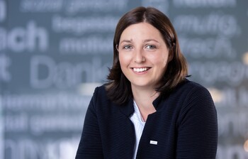 Porträtfoto von Nora Tödtling-Musenbichler vor einem Hintergrund mit Schriftzügen, aufgenommen von Jorj Konstantinov