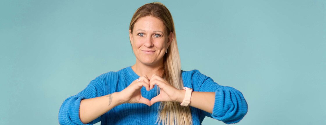 Dame, die mit den Händen ein Herz formt