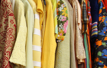 Kleidung, die an einer Kleiderstange hängt.