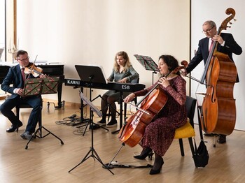 Fünf Musiker geben in einem Saal des Hauses der Musik ein Konzert.