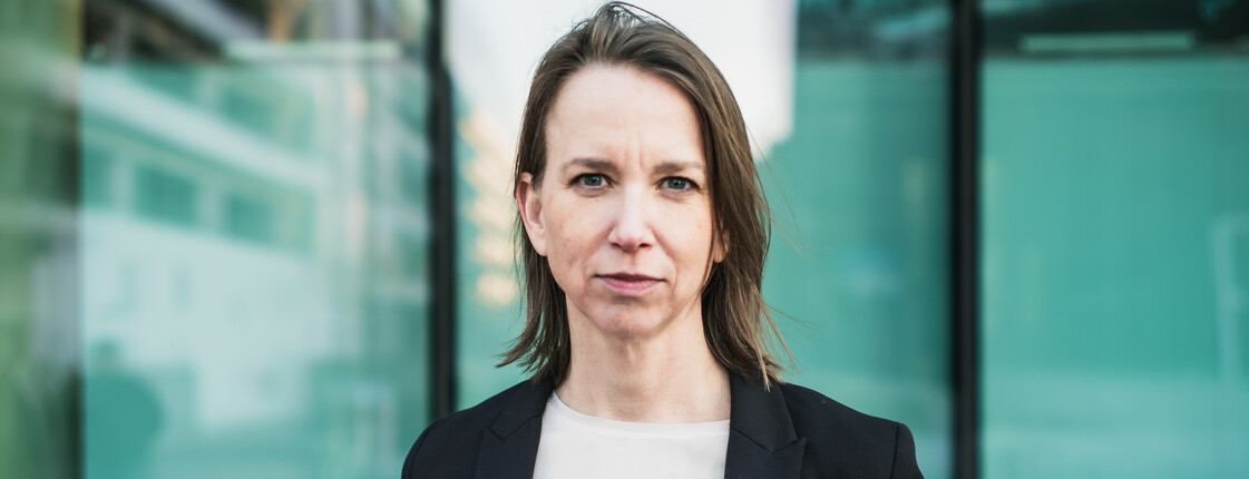 Anna Parr, Generalsekretärin der Caritas Österreich, steht vor einer Fensterfront