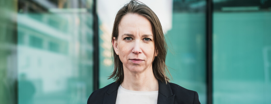 Anna Parr, Generalsekretärin der Caritas Österreich, steht vor einer Fensterfront