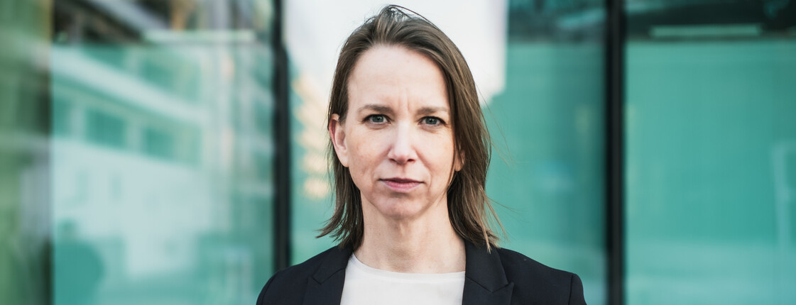 Anna Parr, Generalsekretärin der Caritas Österreich, steht vor einer Fensterfront