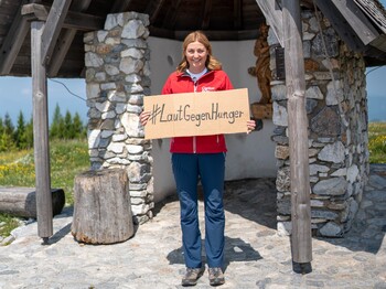 Caritas Österreich-Präsidentin Nora Tödtling-Musenbichler hält ein Schild mit dem Wortlaut "LautGegenHunger"