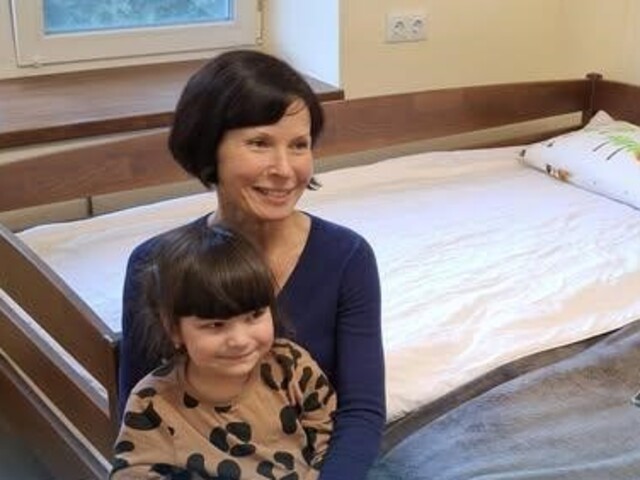 Mutter mit Kind spricht mit Caritas Mitarbeiter*in