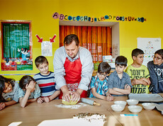 Caritasdirektor Hannes Zieselsberger mit einer Gruppe von Kindern beim Keksebacken