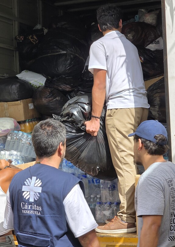 Caritas-Helfer*innen laden Wasserflaschen und Hilfsgüter nach dem Erdbeben in Venezuela aus einem Lkw.