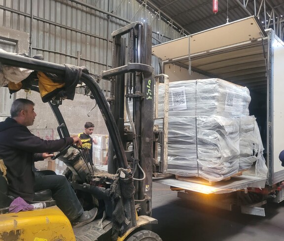 Ein Gabelstapler lädt palettierte Hilfspakete in einen Lkw für die Verteilung.