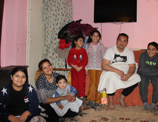 Die beiden Mädchen Joscha und Masche mit ihrer Mutter, ihrem Vater, ihren beiden Brüdern und ihrer Schwester im Wohnzimmer der Familie.