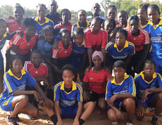 Mehrere Mädchenfußballteams posieren gemeinsam für ein Gruppenfoto.
