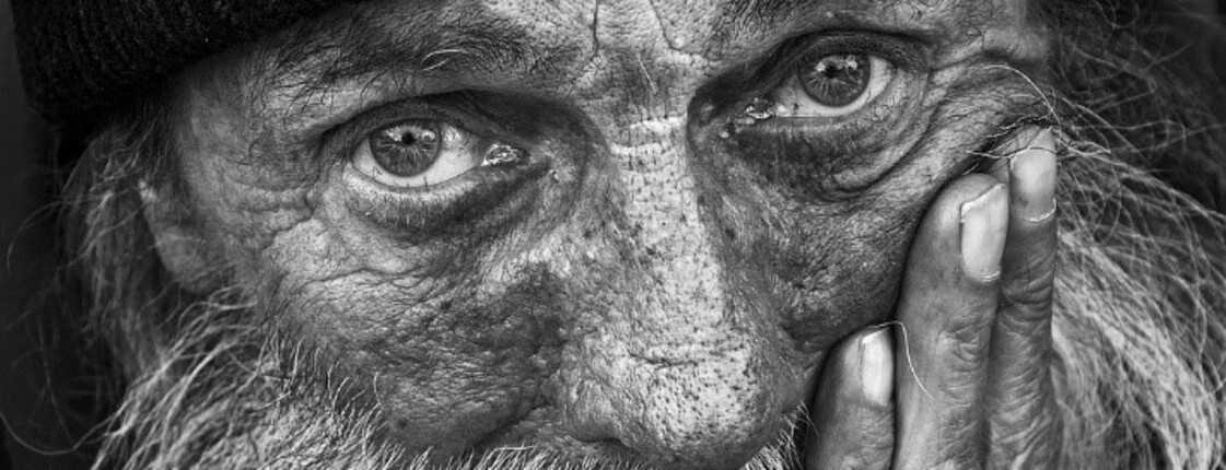 Porträt eines nachdenklichen älteren Mannes  Älterer Mann mit Bart und Mütze blickt ernst in die Kamera, stützt das Gesicht auf seine Hand