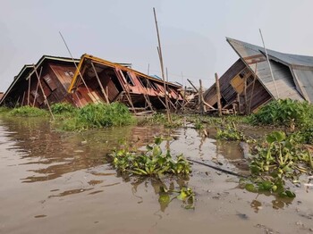 Zerstörte Häuser nach einem Erdbeben sind zu sehen, sie sind auch überflutet.
