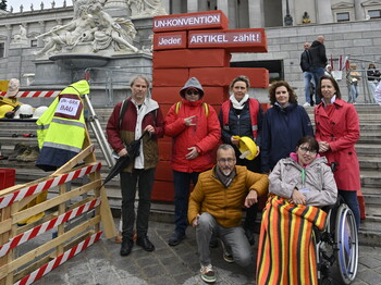Vertreter*innen der Caritas und Teilnehmende an der Aktion "Baustelle Inklusion" befinden sich für ein Gruppenfoto vor dem Parlament