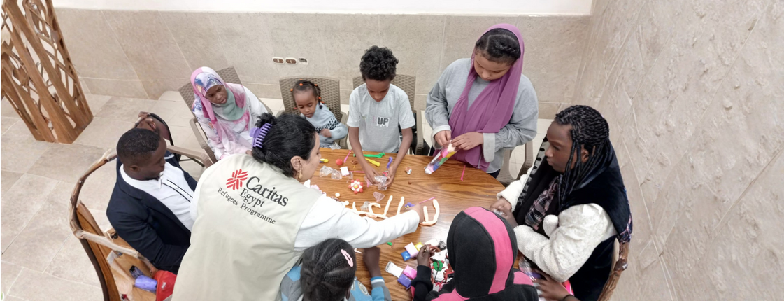 Eine Mitarbeiterin von Caritas Ägypten mit sudanesischen Flüchtlingskindern