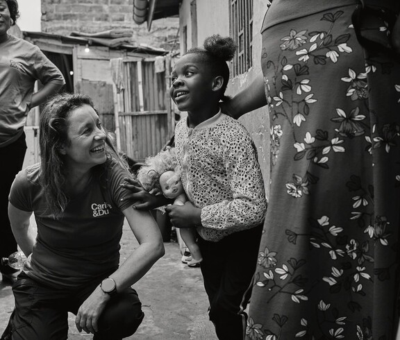 Eine Frau die hockt mit einem Kind