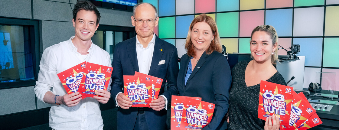 Start der Ö3-Wundertüte 2025: Caritas, Ö3 und Post präsentieren die Aktion Philipp Hansa, Walter Oblin, Nora Tödtling-Musenbichler und Gabi Hiller präsentieren im Ö3-Studio die Ö3-Wundertüte 2025 und halten rote Spendentüten in den Händen.