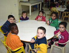 Eine Gruppe Kinder sitzt an einem Esstisch