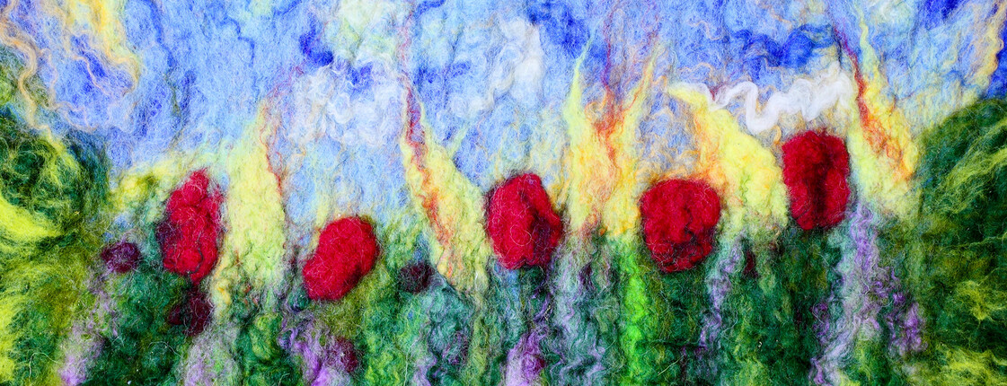 Tapestry of fulled wool meadow with tulips. Handmade textile - carpet texture background. Colored white, blue, green, red tapestry with multicolored decorative pattern. Traditions craft and decor of interior.