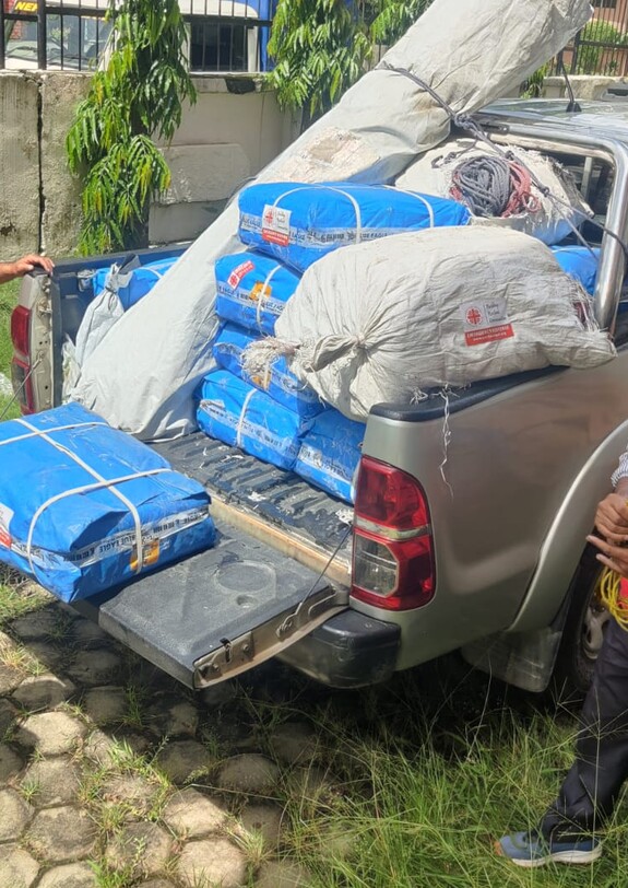 Caritas-Mitarbeitende bereiten Hilfsgüter auf einem Geländewagen für den Einsatz nach der Flut in Nepal vor.