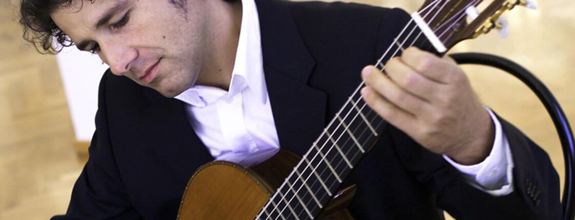 Ein Herr mittleren Alters spielt auf einer Gitarre.