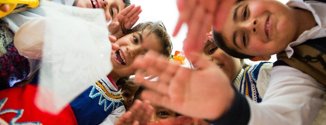 Kinder sitzen an Tischen und lernen