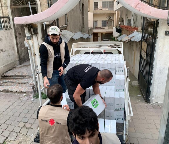 Mitarbeiter*innen der Caritas verladen Hilfsgüter für die Menschen in Syrien