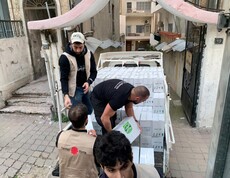 Mitarbeiter*innen der Caritas verladen Hilfsgüter für die Menschen in Syrien