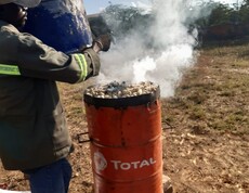 Im Projekt PERDURER werden Maiskolben karbonisiert, um Biokohle herzustellen  Ein Mann befüllt einen Metallofen mit Maiskolben, aus dem Rauch aufsteigt.