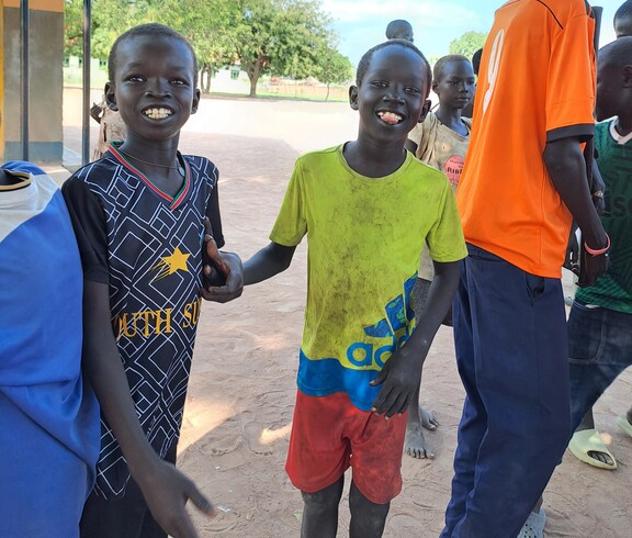 ein paar junge Südsudanesen lächeln in die Kamera und sind fröhlich. 