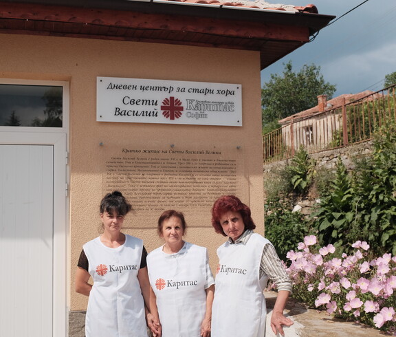 Drei Frauen in Caritas Westen stehen vor einem Gebäude und blicken in die Kamera.
