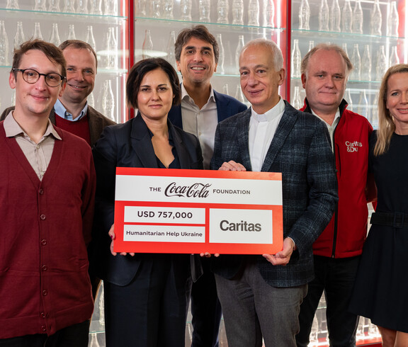 Vertreter*innen von Coca-Cola und Caritas Österreich bei der Scheckübergabe