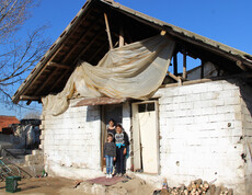 Messi steht mit seiner Mutter und einer seiner Schwestern vor ihrem baufälligen Haus.