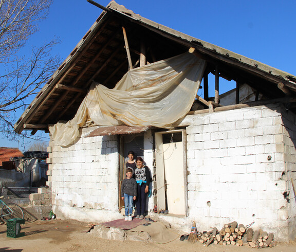 Messi steht mit seiner Mutter und einer seiner Schwestern vor ihrem baufälligen Haus.