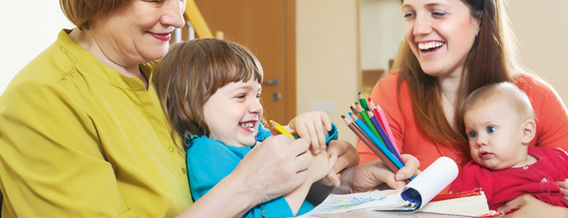 Eine Familie sitzt am Tisch und ist am basteln