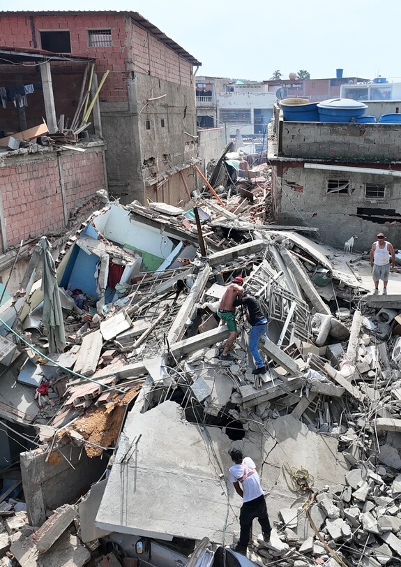 Eingestürzte Wohnhäuser und Menschen zwischen Trümmern nach dem Erdbeben in La Guaira, Venezuela.
