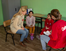 Eine Caritas-Projektreferentin im Gespräch mit den beiden Mädchen Joscha und Mascha im Bildungszentrum.