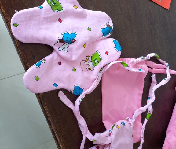 auf einem Tisch liegen mehrere selbstgenähte rosa Stoffbinden
