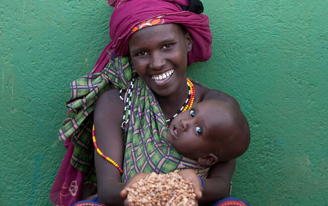 Frau mit Getreide und Baby in Kenia