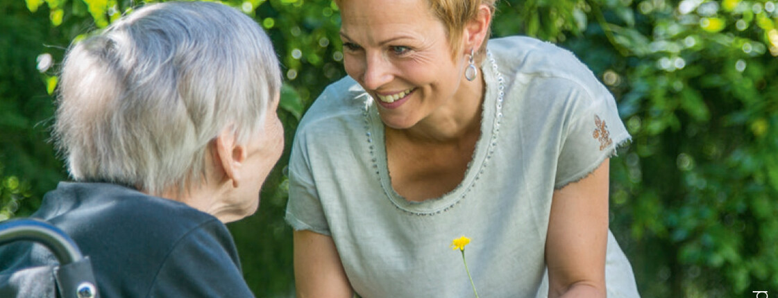 Frau hilft einer alten Frau