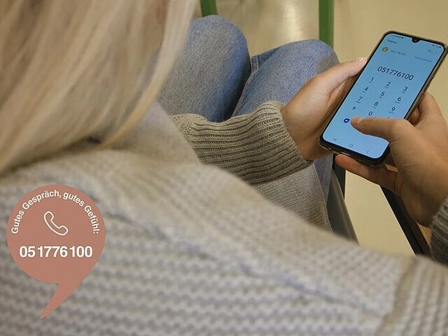 Frau wählt auf ihrem Smartphone die Telefonnummer 05 1776 100 des Plaudernetzes, einer Initiative, die Menschen für anonyme Gespräche verbindet.